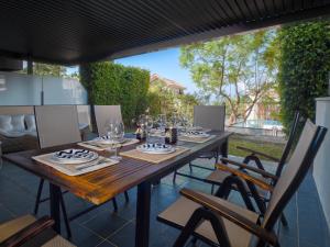 a wooden table and chairs on a patio at Amazing Two Bedroom Apartment in Los Flamingos, Marbella in Estepona
