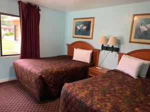 a hotel room with two beds and a window at Travel Inn Daytona in Daytona Beach