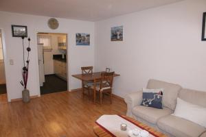 a living room with a couch and a table at Ferienwohnung Schönfeld auf Fehmarn in Petersdorf auf Fehmarn