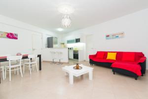 a living room with a red couch and a table at Apartamento Praia Fuzeta in Fuzeta