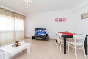 a living room with a table and a tv at Apartamento Praia Fuzeta in Fuzeta