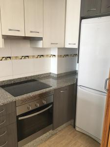 een keuken met een witte koelkast en bruine kasten bij alojamiento vistas al mar in Cartagena