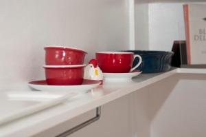 two red cups and saucers sitting on a shelf at Paddington Pad in Sydney