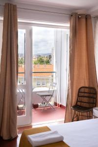 a bedroom with a bed and a balcony with a view at 4U Lisbon Suites & Guesthouse VII Airport in Lisbon