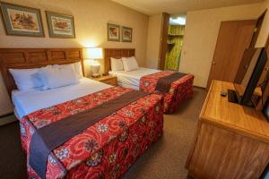 a hotel room with two beds and a television at Wedgewood Resort in Fairbanks