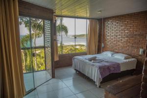 a bedroom with a bed with a view of the ocean at Pousada Estação Baleia in Praia do Rosa +88 photos