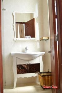 ein Badezimmer mit einem weißen Waschbecken und einem Spiegel in der Unterkunft Mountain Town Hotel in Da Lat