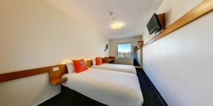雪梨的住宿－悉尼機場宜必思快捷酒店，一间酒店客房,设有两张床和电视