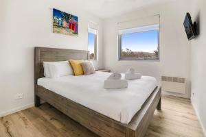 a bedroom with a large bed and a window at Seaside Apartment Getaway in Dromana