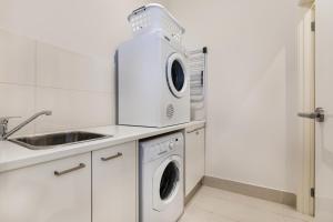 a kitchen with a washing machine and a sink at Seaside Apartment Getaway in Dromana