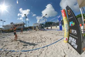 a group of people playing volleyball on a beach at Eagle Aruba Resort & Casino in Palm-Eagle Beach