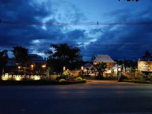 a night view of a house with lights on a street at Heanmaeloung Resort. in Chiang Mai