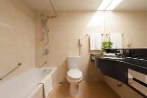 
a bathroom with a tub, toilet and sink at Ramada by Wyndham Pearl Guangzhou in Guangzhou
