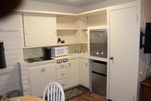 eine kleine Küche mit weißen Schränken und einem Waschbecken in der Unterkunft Little European Lodge in Carmel Valley