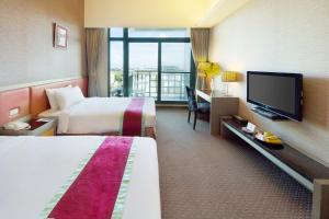 Habitación de hotel con 2 camas y TV de pantalla plana. en Formosan Naruwan Garden Hotel, en Taitung