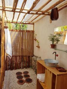 an outdoor bathroom with a sink and a shower at El Búho Glamping Bacalar in Bacalar