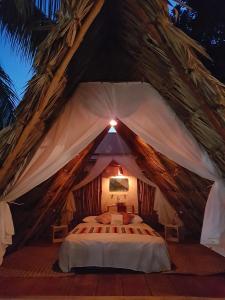 een slaapkamer met een bed in een tent bij El Búho Glamping Bacalar in Bacalar