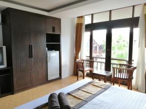 a bedroom with a bed and two chairs and a window at Arina Boutique Residence in Chaweng