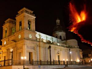 un grande edificio con una torre dell'orologio di notte di A Casa Olimpia Giarre tra Taormina, Etna e Catania a Giarre