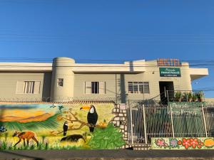 a building with a painting on the side of it at Pousada e Hostel Passos I Suítes in Passos