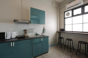 a kitchen with green cabinets and a sink and a window at Loft Series by Pak-Up in Krabi