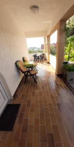 a patio with chairs and a table on a tiled floor at Apartmani Lana Rab in Rab