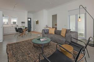 uma sala de estar com um sofá e uma mesa em Perla em Hermanus