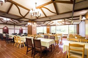 a dining room with white tables and chairs at Toyokawa Grand Hotel in Toyokawa