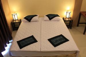 1 cama grande con sábanas y almohadas blancas en Avalon Residence, en Savannakhet