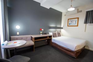 سرير أو أسرّة في غرفة في The Midcity Motor Lodge