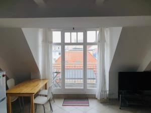 a living room with a table and a large window at Kehrwieder in Warnemünde