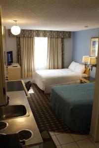 um quarto de hotel com duas camas e um lavatório em Hillcrest Motel em Swan Hills
