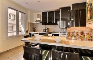 a kitchen with a counter with chairs in it at Lyon Superbe Appartement Parc Tête d'Or 95 M2 Clim Parking in Lyon