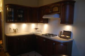 a kitchen with wooden cabinets and a stove top oven at Ogarna 88 in Gdańsk
