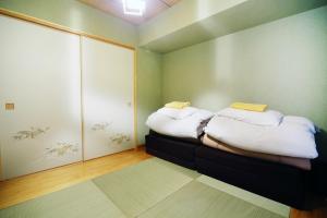 Habitación pequeña con 2 camas. en Shinjuku Tenjin 4F, en Tokio