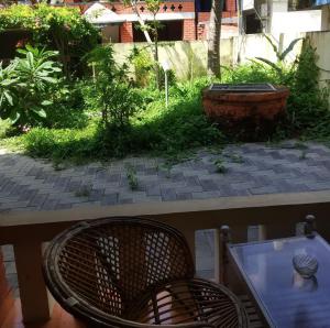 uitzicht op een patio met een tafel en een stoel bij Hotel Thushara in Kovalam