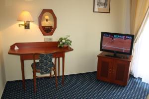 a hotel room with a desk and a television at Dům Bedřicha Smetany in Luhačovice