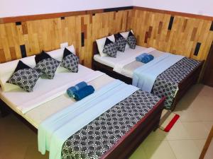 two beds in a room next to each other at Polo Region Rest Inn in Haputale
