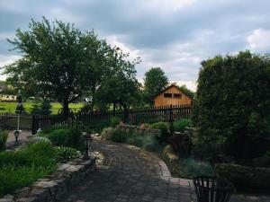 a garden with a fence and a brick walkway at Appartement & Pension Schmidt Kosma in Altenburg