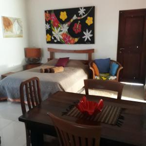 a bedroom with a bed and a table and a painting at Piafau Hills in Faaa