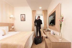 Um homem está num quarto de hotel. em Grand Hotel Coroana em Bistriţa