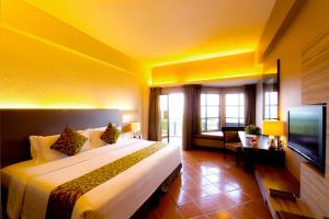 Habitación de hotel con cama grande y TV en Thistle Port Dickson Resort, en Port Dickson