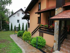 a house with flowers on the side of it at Apartments Dobra Vila in Zlatibor