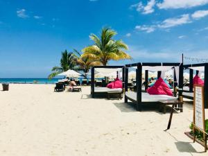 a group of beds on the beach at CondoHotel 5th Avenue Basic Double Studio in Playa del Carmen