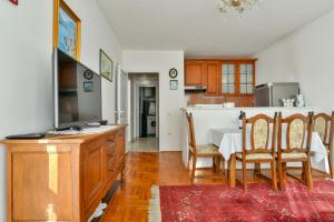 a kitchen and dining room with a table and a television at Apartment Ruzica in Sveti Stefan