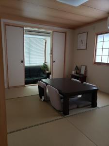 a living room with a table and a couch at GardenRoom bnb Yumyum in Nagasaki