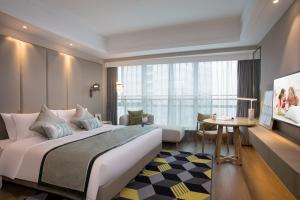 a hotel room with a large bed and a table at Citadines Keqiao Shaoxing in Shaoxing +31 photos