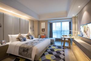 a hotel room with a large bed and a television at Citadines Keqiao Shaoxing in Shaoxing
