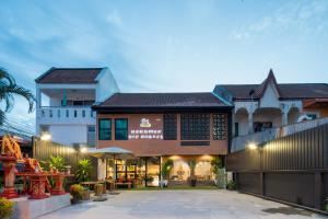 an exterior view of a building with a courtyard at Hanuman VIP Hostel - SHA Plus in Bang Tao Beach