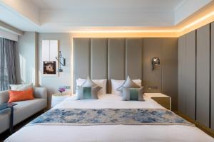 a bedroom with a large bed and a couch at Citadines Keqiao Shaoxing in Shaoxing